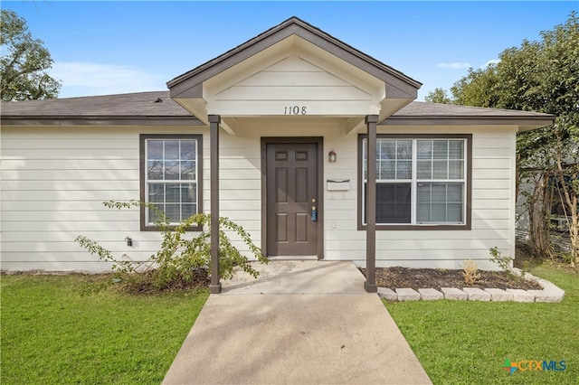 entrance to property with a lawn