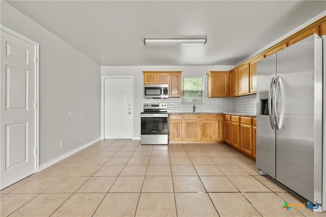 kitchen featuring light tile patterned floors, appliances with stainless steel finishes, and decorative backsplash