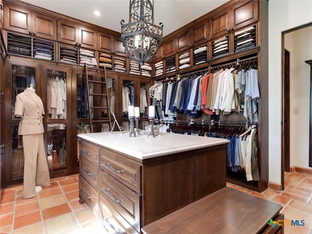 spacious closet featuring a notable chandelier and light tile patterned floors