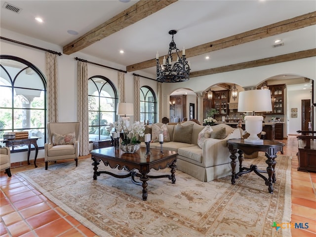 tiled living room featuring a notable chandelier and beam ceiling