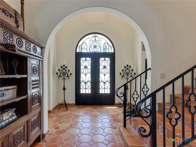 entryway featuring lofted ceiling and french doors