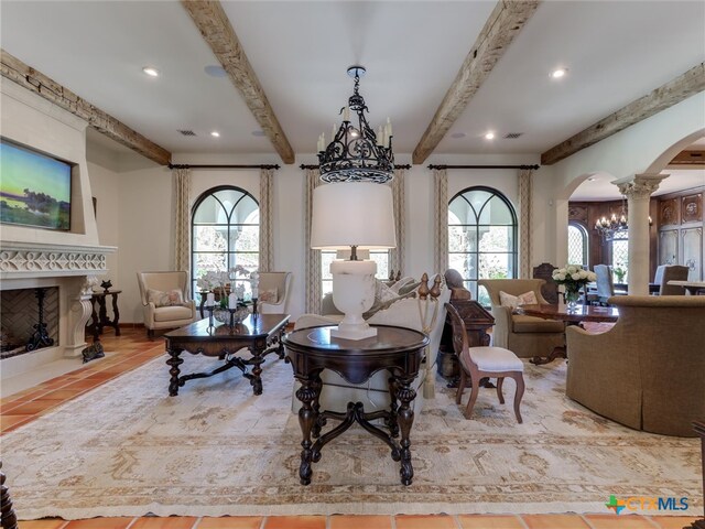 living room featuring beamed ceiling and decorative columns