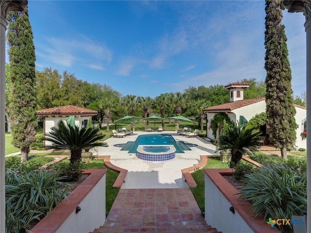 view of swimming pool featuring an in ground hot tub and a patio area