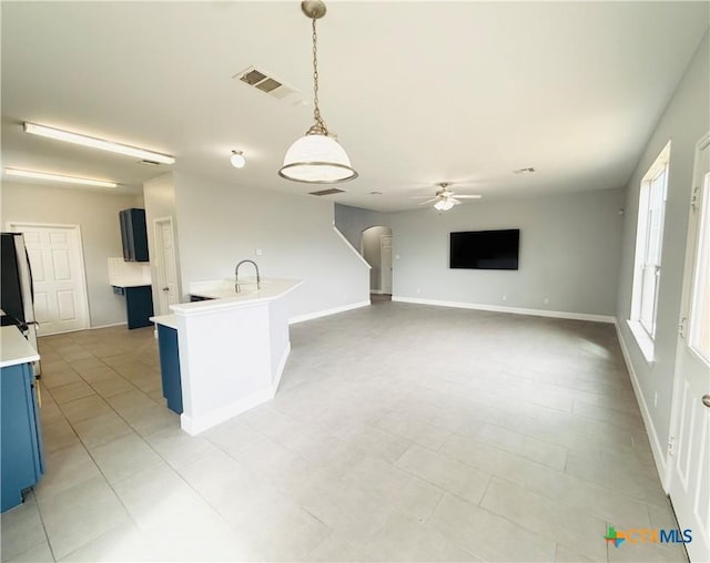 4302 Jack Barnes Ave, Killeen, TX 76549 - kitchen with blue cabinetry, arched walkways, light countertops, ceiling fan, and hanging light fixtures