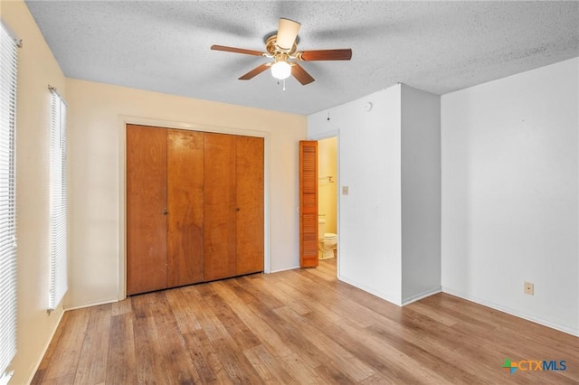 unfurnished bedroom featuring ceiling fan, a closet, a textured ceiling, and light hardwood / wood-style flooring