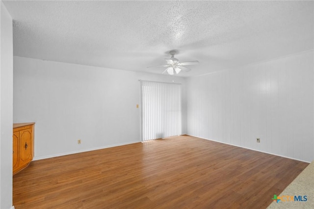 empty room featuring ceiling fan, wood-type flooring, and a textured ceiling