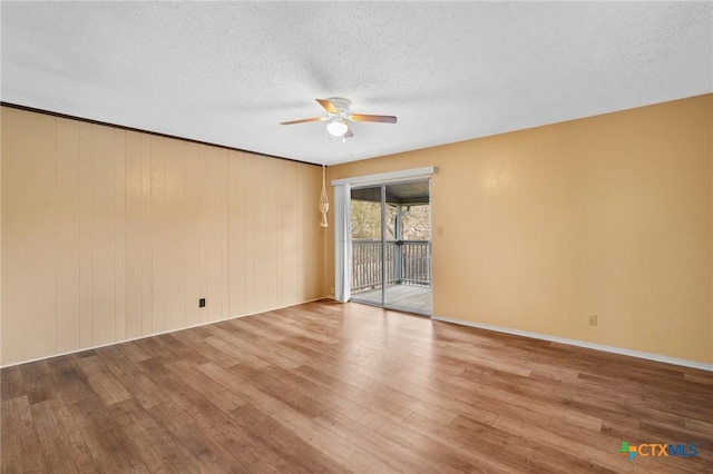 spare room with ceiling fan, a textured ceiling, and light wood-type flooring