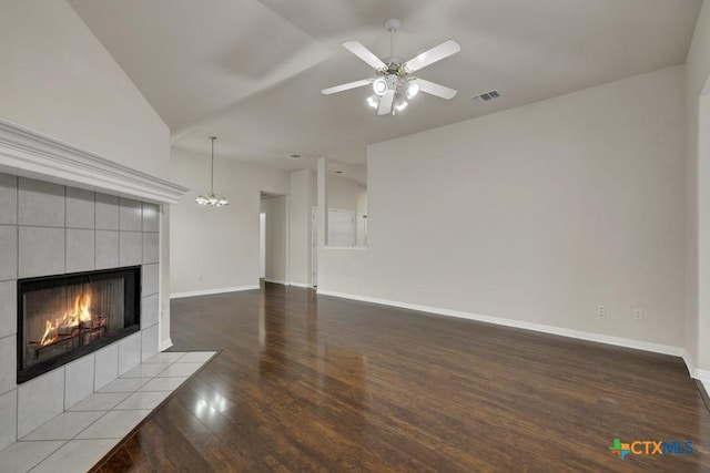 2121 Keystone Dr, New Braunfels, TX 78130 - unfurnished living room featuring a tiled fireplace, wood finished floors, lofted ceiling, a ceiling fan, and baseboards