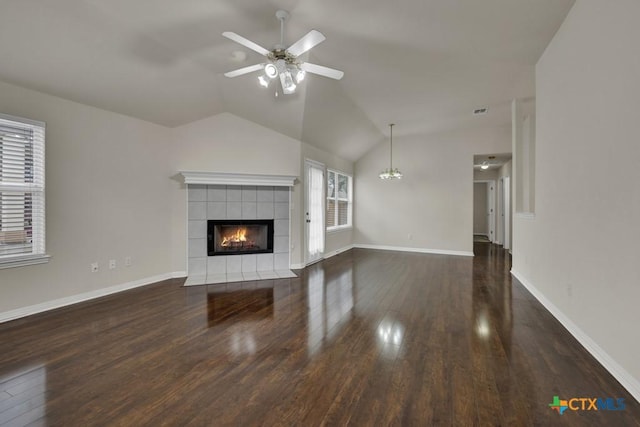 2121 Keystone Dr, New Braunfels, TX 78130 - unfurnished living room with wood finished floors, a tiled fireplace, a ceiling fan, lofted ceiling, and baseboards