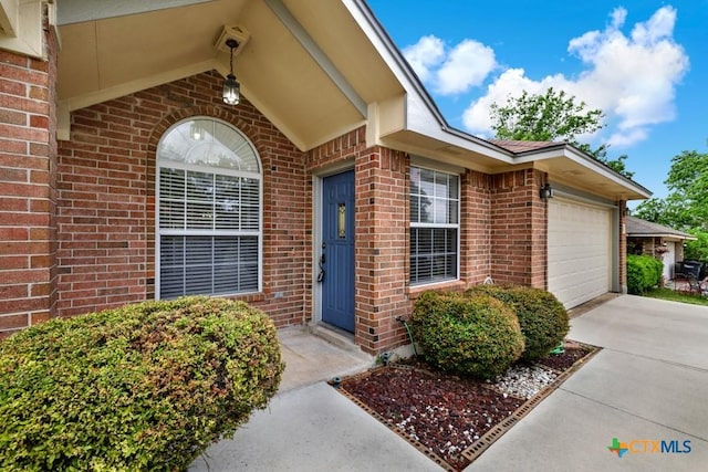 2121 Keystone Dr, New Braunfels, TX 78130 - view of exterior entry featuring brick siding, an attached garage, and driveway