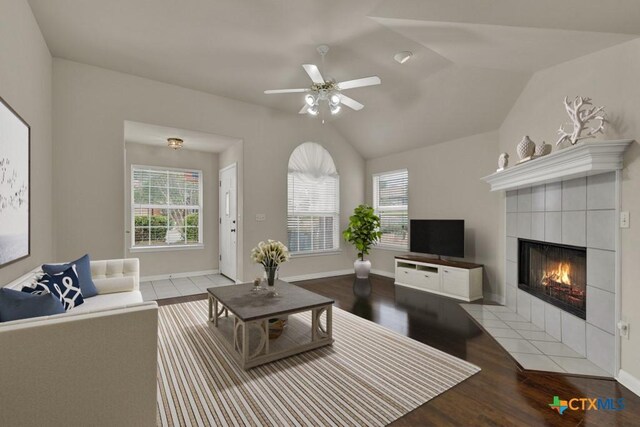 2121 Keystone Dr, New Braunfels, TX 78130 - living room featuring a tiled fireplace, a ceiling fan, wood finished floors, lofted ceiling, and baseboards