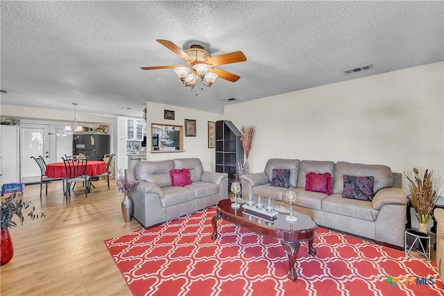 3602 Bacon Ranch Rd, Killeen, TX 76542 - living room with wood finished floors, a textured ceiling, and a ceiling fan