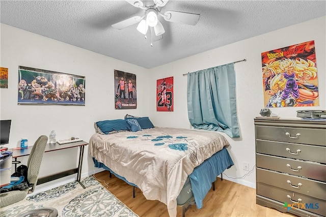 3602 Bacon Ranch Rd, Killeen, TX 76542 - bedroom with wood finished floors, a textured ceiling, baseboards, and a ceiling fan