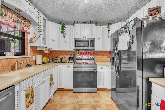 3602 Bacon Ranch Rd, Killeen, TX 76542 - kitchen with appliances with stainless steel finishes, a sink, light countertops, light tile patterned floors, and white cabinets