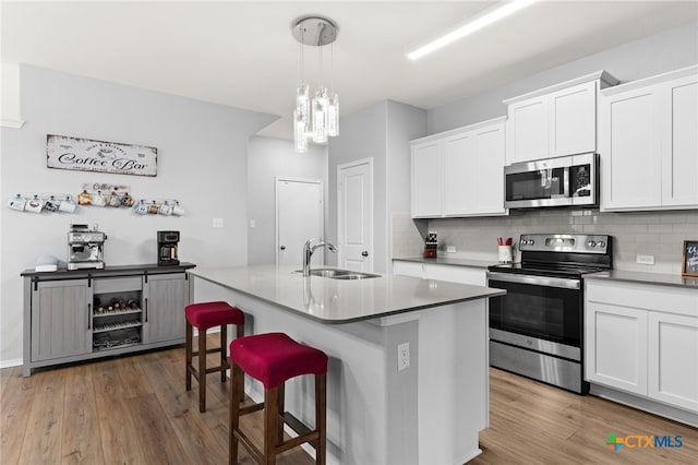 421 Perfect World Loop, Jarrell, TX 76537 - kitchen featuring stainless steel appliances, a sink, wood finished floors, and decorative backsplash