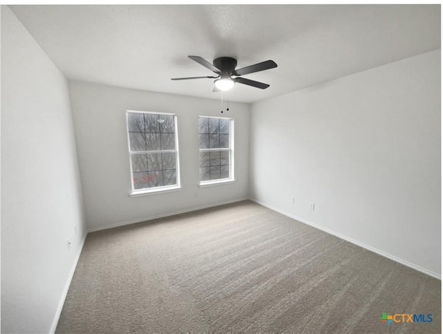 carpeted spare room with ceiling fan