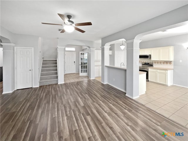 unfurnished living room featuring ceiling fan, sink, and light hardwood / wood-style flooring