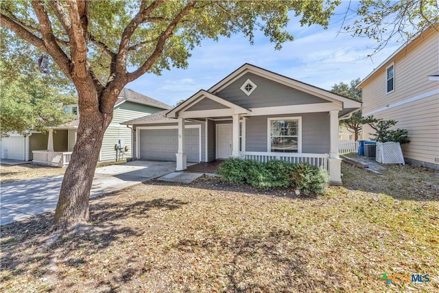 view of front of house featuring driveway, covered porch, and a garage