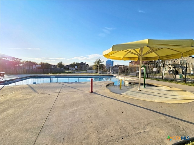 community pool featuring a patio area and fence