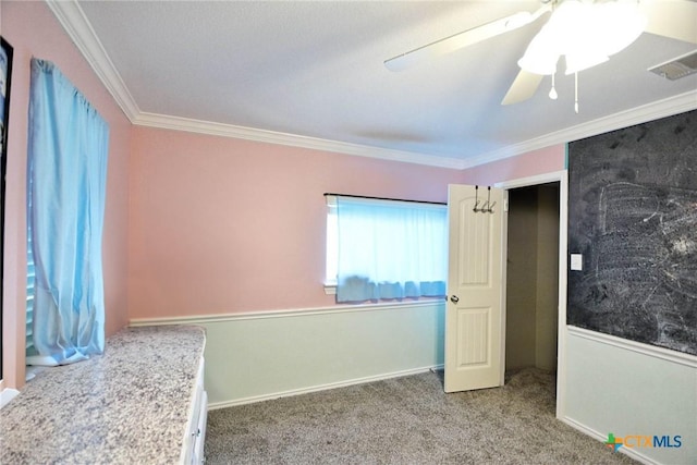 unfurnished bedroom with visible vents, carpet floors, crown molding, baseboards, and ceiling fan