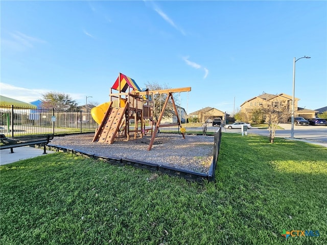 community playground with a lawn and fence