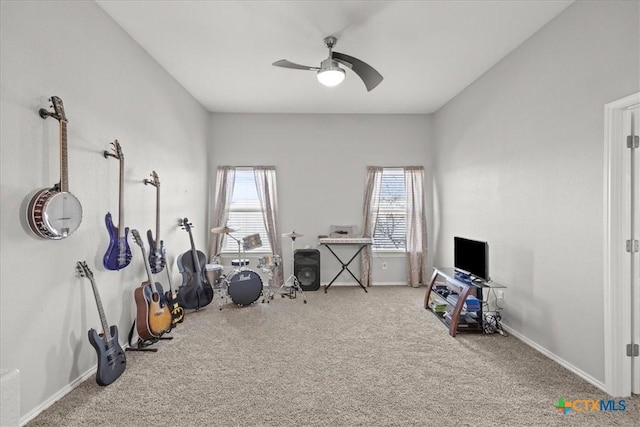 exercise area with baseboards, carpet, and ceiling fan