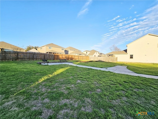 view of yard with a patio area, fence, and a residential view