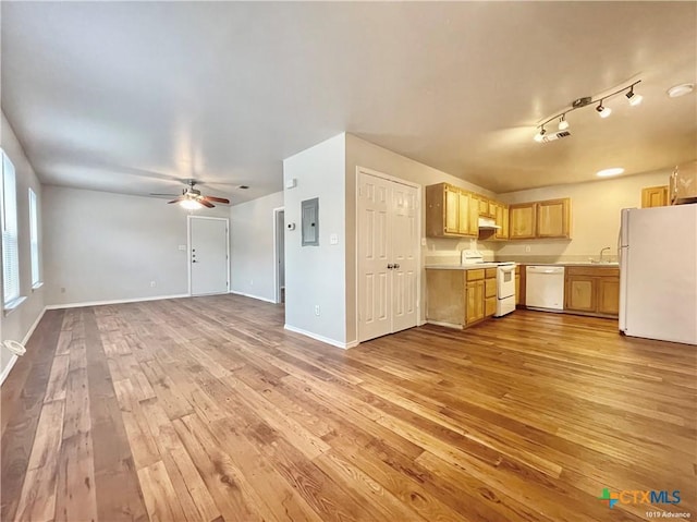 kitchen featuring white appliances, sink, electric panel, and light hardwood / wood-style flooring