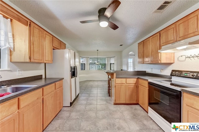 kitchen with kitchen peninsula, a textured ceiling, sink, ceiling fan, and white appliances