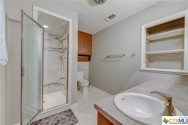 bathroom featuring a shower with door, vanity, toilet, and a textured ceiling