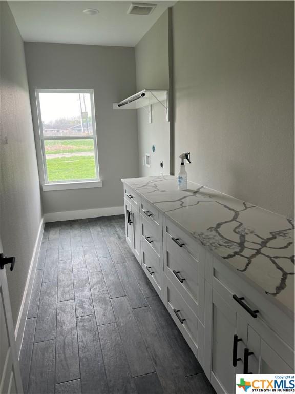 303 Claret, Port Lavaca, TX 77979 - laundry room featuring dark wood-style floors and baseboards