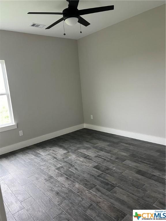 303 Claret, Port Lavaca, TX 77979 - empty room with ceiling fan and dark wood-type flooring