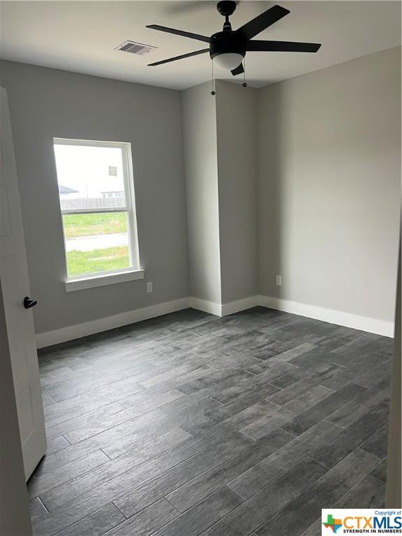 303 Claret, Port Lavaca, TX 77979 - spare room featuring a ceiling fan and dark wood-style floors
