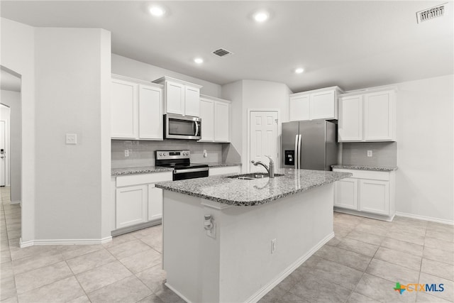 kitchen with white cabinetry, sink, tasteful backsplash, an island with sink, and appliances with stainless steel finishes