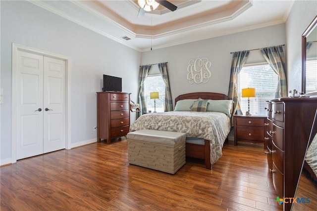 1332 Walker Cir, Salado, TX 76571 - bedroom with multiple windows, dark wood finished floors, ornamental molding, a tray ceiling, and a ceiling fan