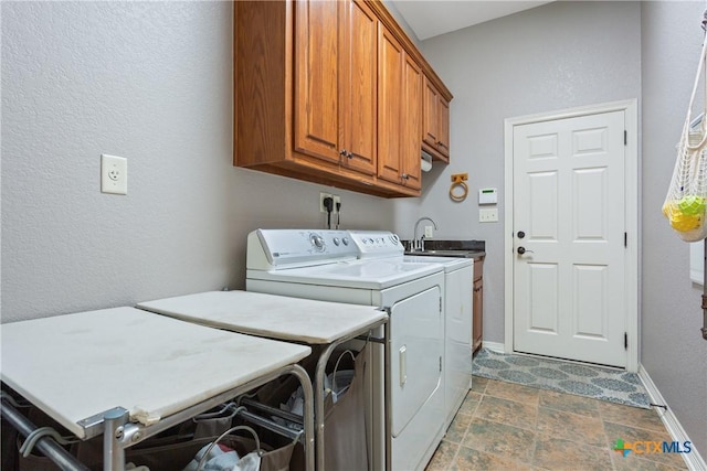 1332 Walker Cir, Salado, TX 76571 - laundry area featuring washer and clothes dryer, cabinet space, baseboards, stone finish floors, and a textured wall