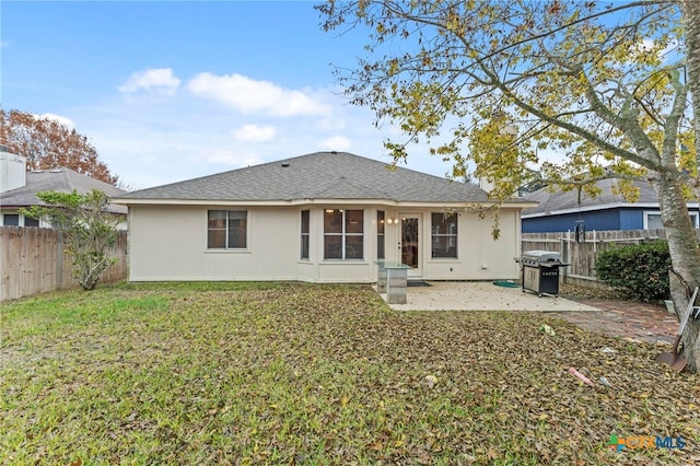 rear view of property featuring a lawn and a patio area