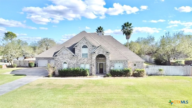 french country style house with a front yard and a garage