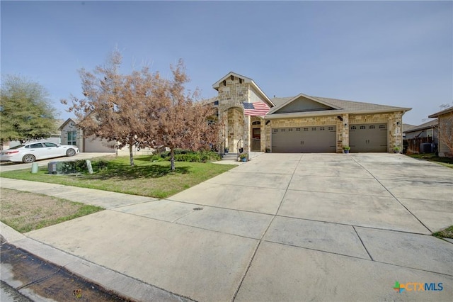 view of front of house with a front yard, cooling unit, driveway, an attached garage, and stone siding