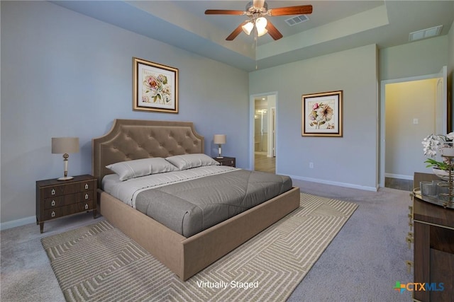 bedroom featuring a raised ceiling, baseboards, and visible vents