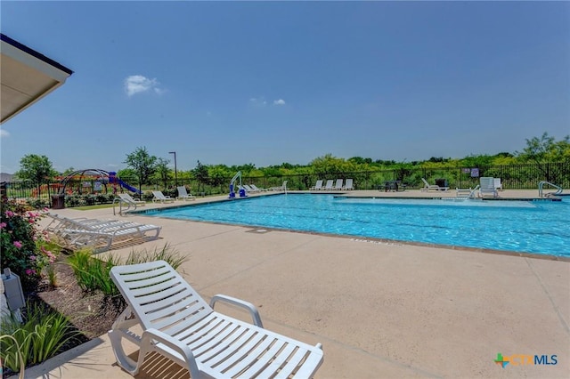 pool with a patio and fence