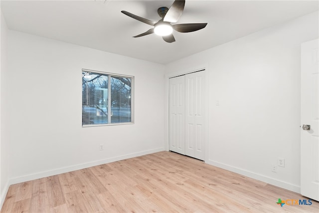 unfurnished bedroom with ceiling fan, a closet, and light hardwood / wood-style flooring