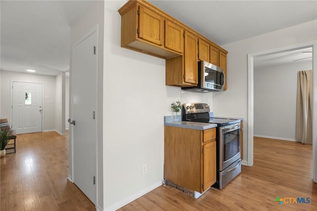 2002 E Young Ave, Temple, TX 76501 - kitchen featuring appliances with stainless steel finishes, light wood-style floors, brown cabinets, baseboards, and recessed lighting