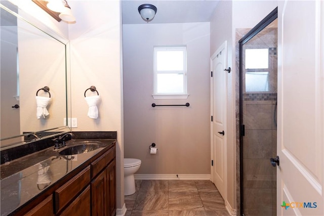 bathroom with toilet, a shower with shower door, and vanity