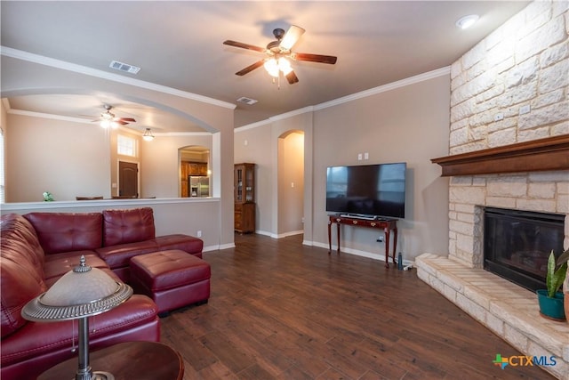 living room featuring ceiling fan, crown molding, a fireplace, and wood-type flooring