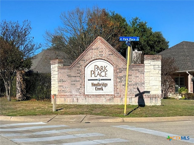 community / neighborhood sign with a yard