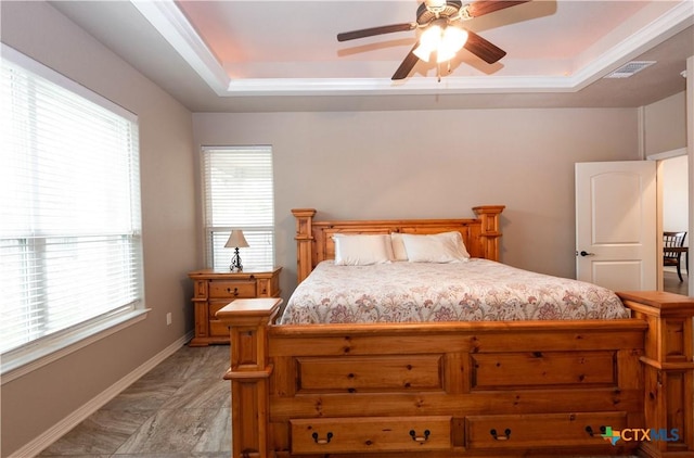 bedroom with a raised ceiling and ceiling fan