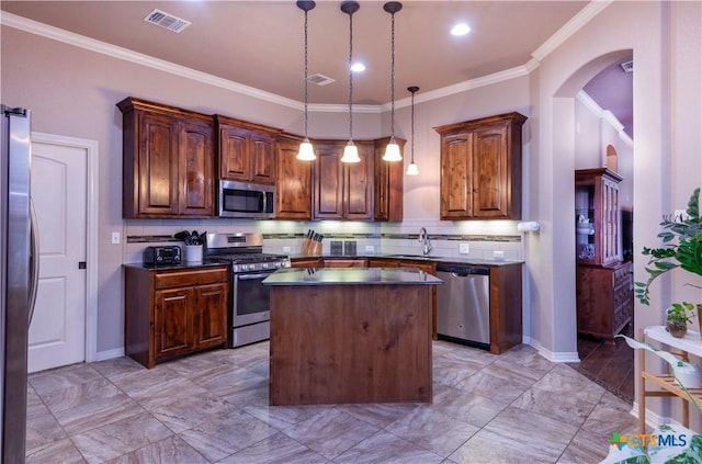 kitchen featuring backsplash, pendant lighting, a center island, sink, and appliances with stainless steel finishes