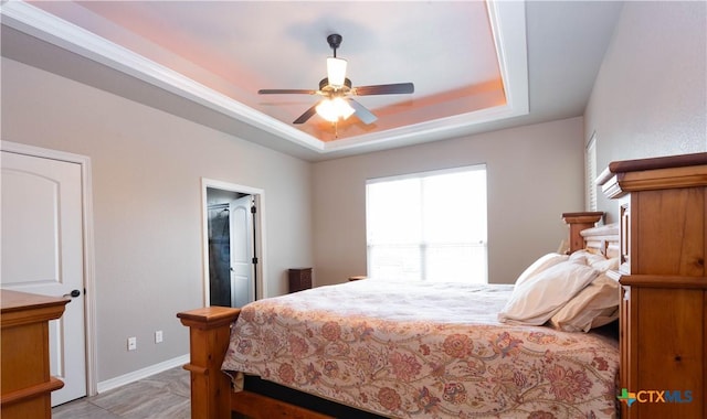 bedroom with ceiling fan and a raised ceiling