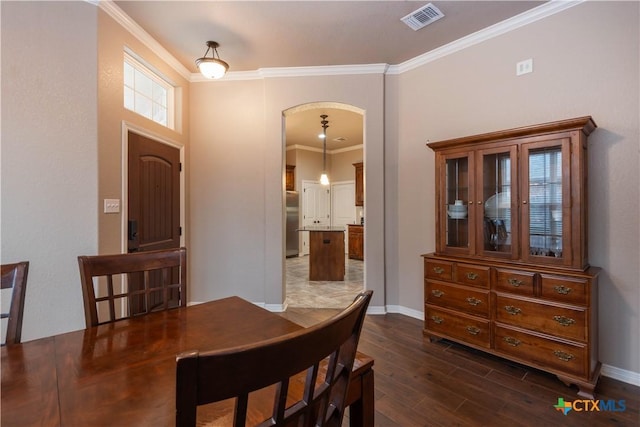 dining area featuring dark hardwood / wood-style flooring and crown molding